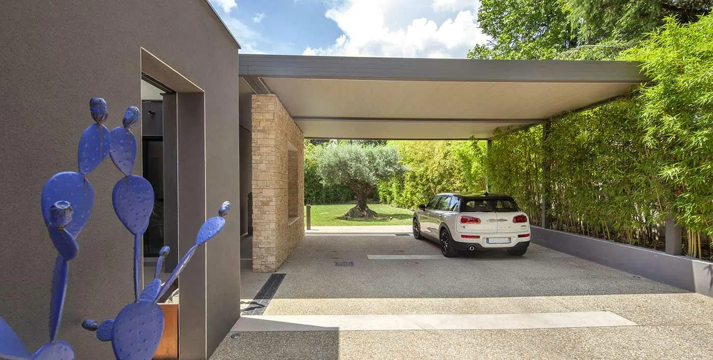 Grand carport avec voiture blanche vue de dos